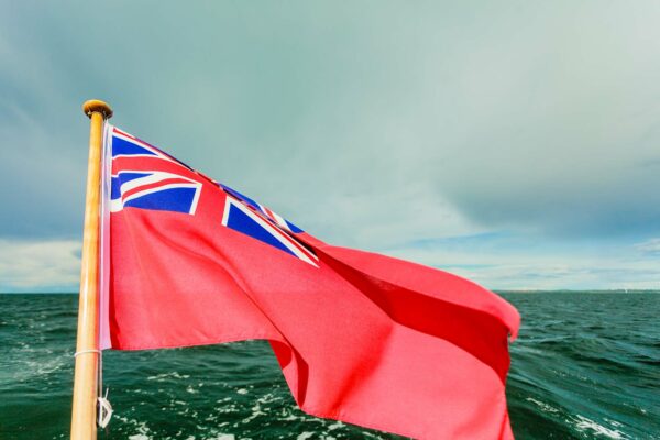 Red ensign flag flying on back of boat over the sea