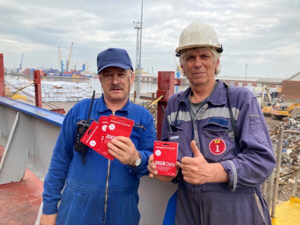 two Ukrainian seafarers holding SIM cards donated by Vodafone