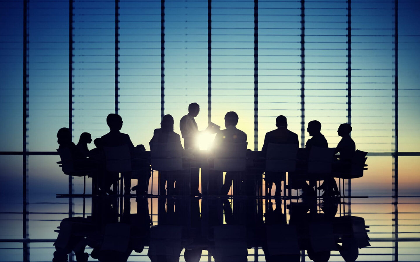 silhouette of board from meeting against sunset background